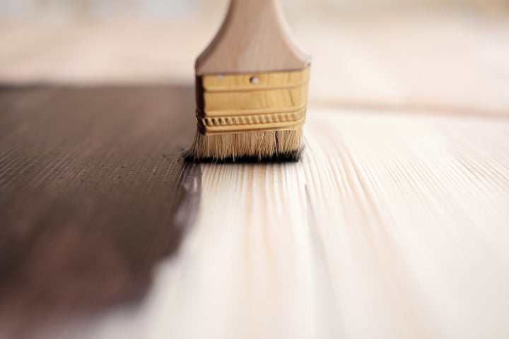 Brush applying finishing stain to Amish hardwood furniture