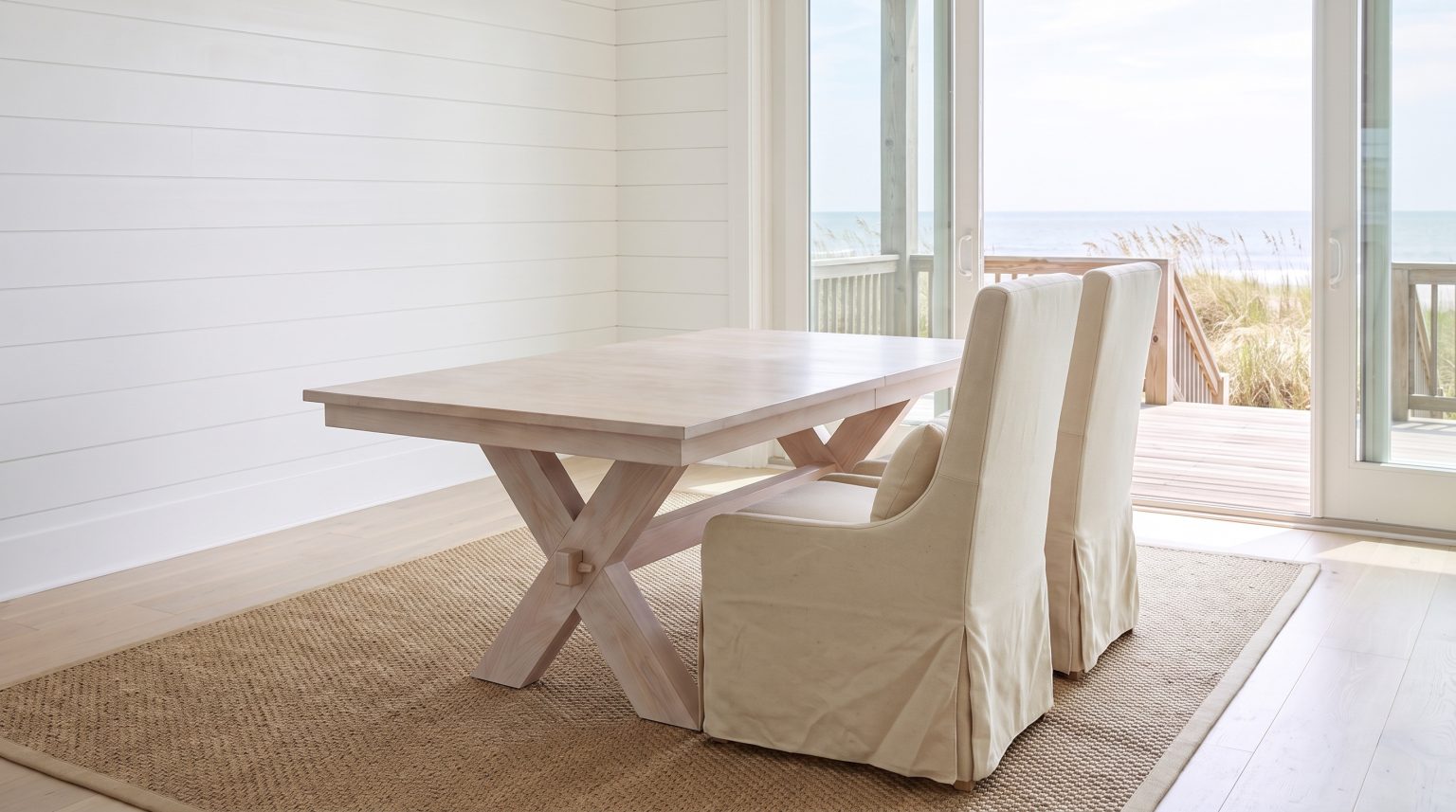 Two linen host chairs: Loose cream slipcovers with a lumbar pillow each.