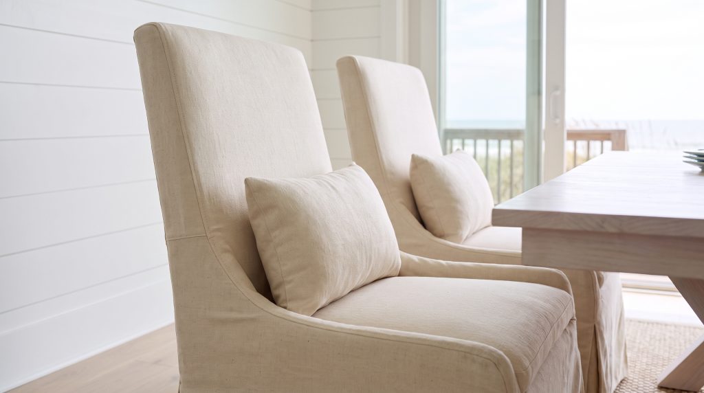 Linen folds: Cream slipcover and lumbar pillow in soft light.