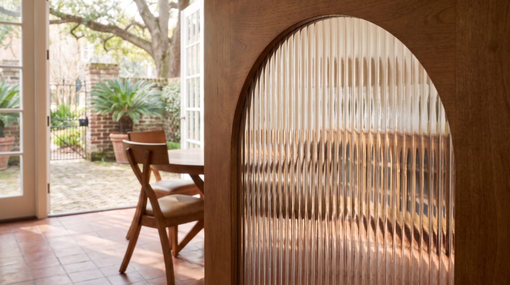 Reeded glass: The arched top of a reeded-glass door in its wooden frame.