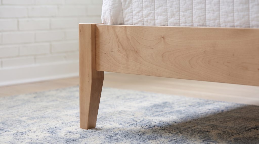 The tapered leg: A slim square leg narrowing from the rail to the floor.