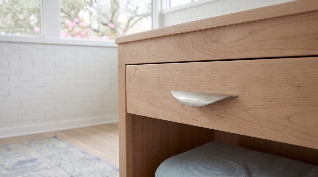 Nickel on maple: A curved brushed-nickel pull over the open shelf.