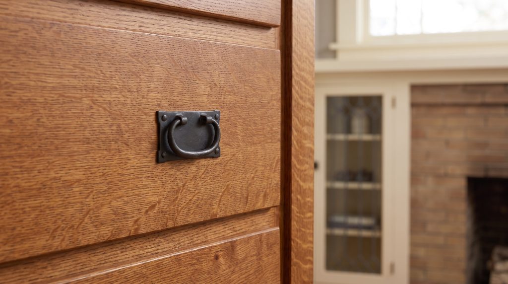 Iron on quartersawn oak: A black iron ring pull set into ray-flecked oak.