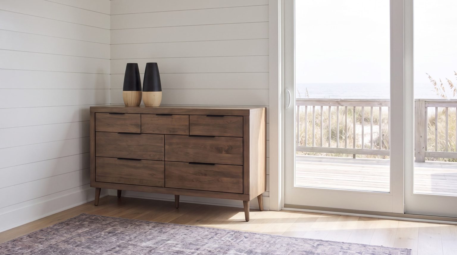 The six-drawer dresser: Two rows of three drawers with slim black pulls on tapered legs.