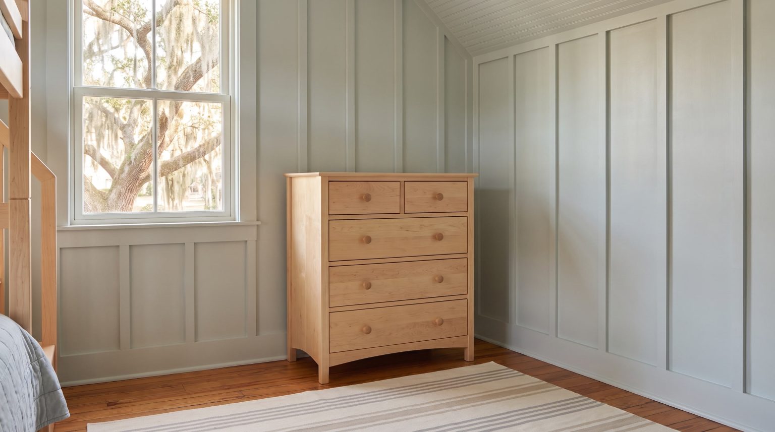The maple dresser: Two small drawers over full-width drawers with wooden knobs.