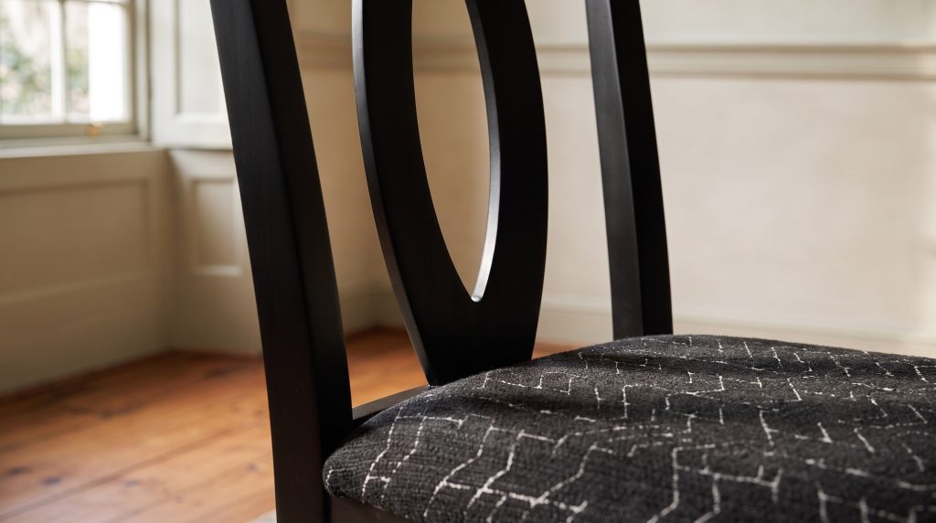 Oval back and seat: The black oval splat over a charcoal seat with a fine white pattern.