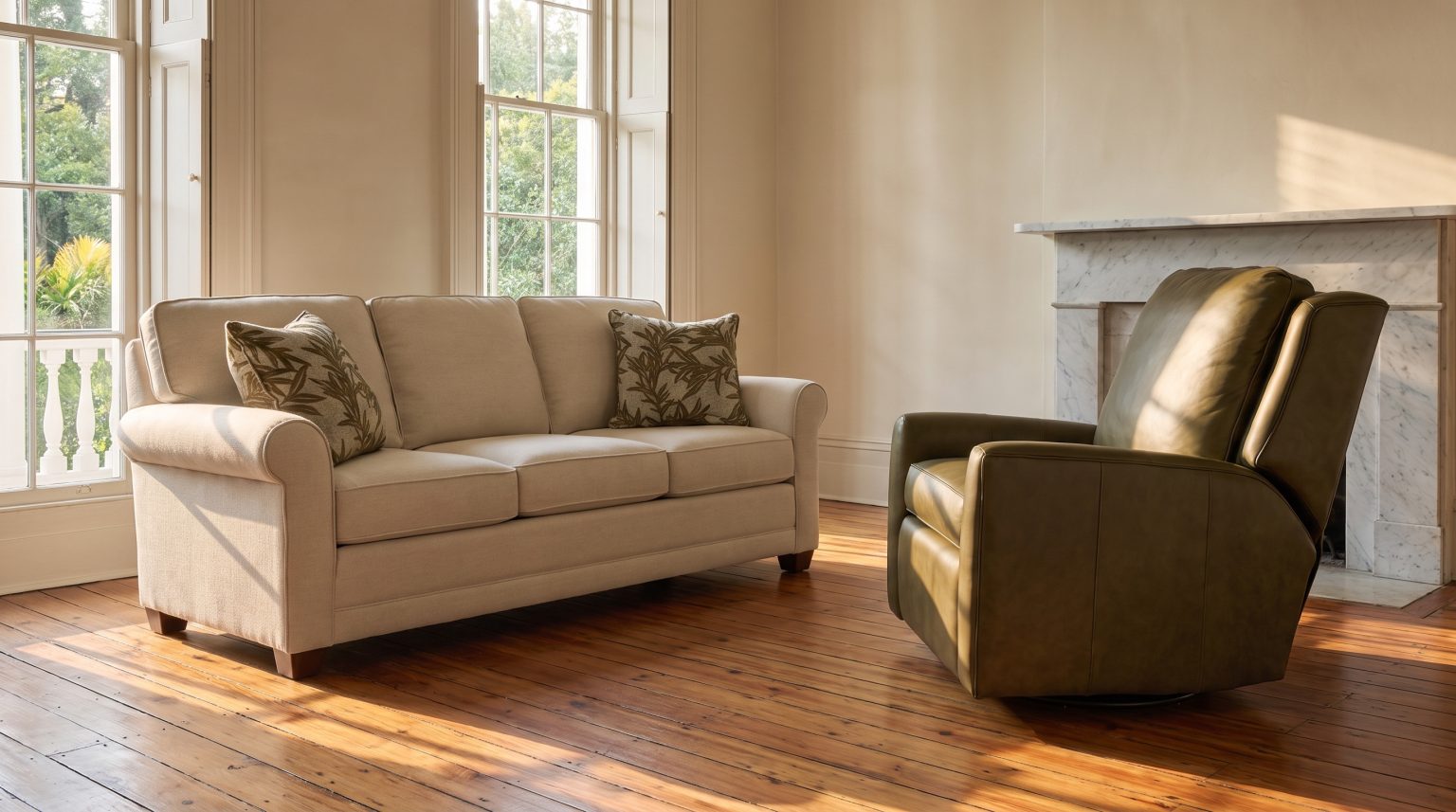 A cream sofa with three back cushions and three seat cushions beside an olive-green leather recliner on heart pine
