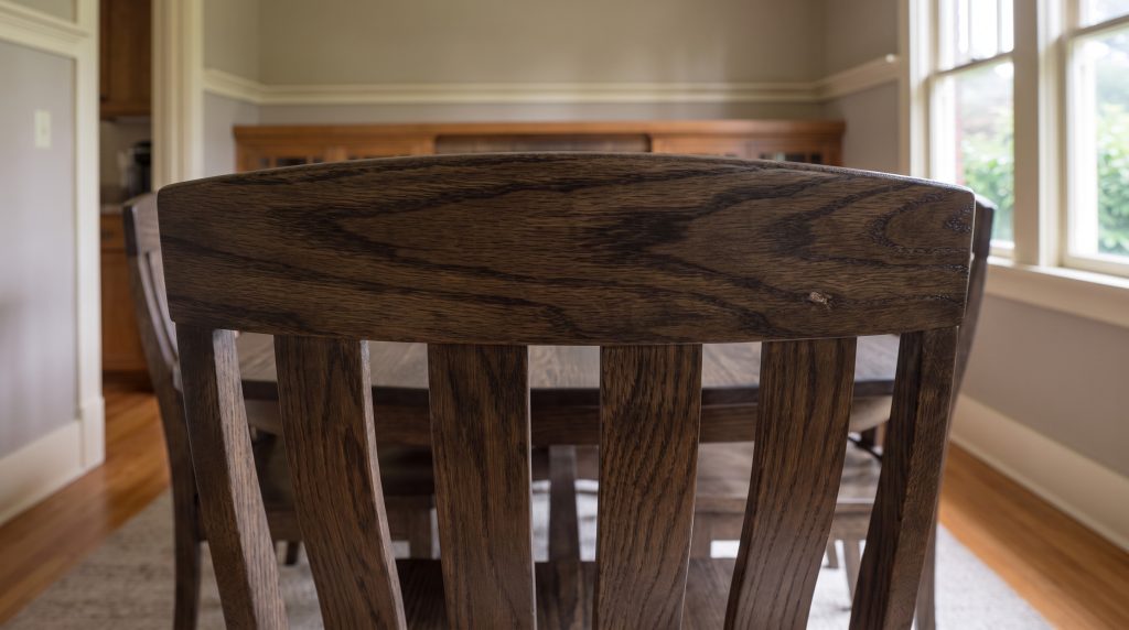 A close view of a deep flat quartersawn oak crest rail with flat slats curving away beneath it
