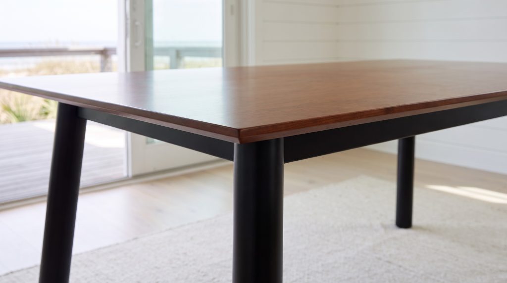 The square cherry edge overhanging the black skirt at the corner of the table.