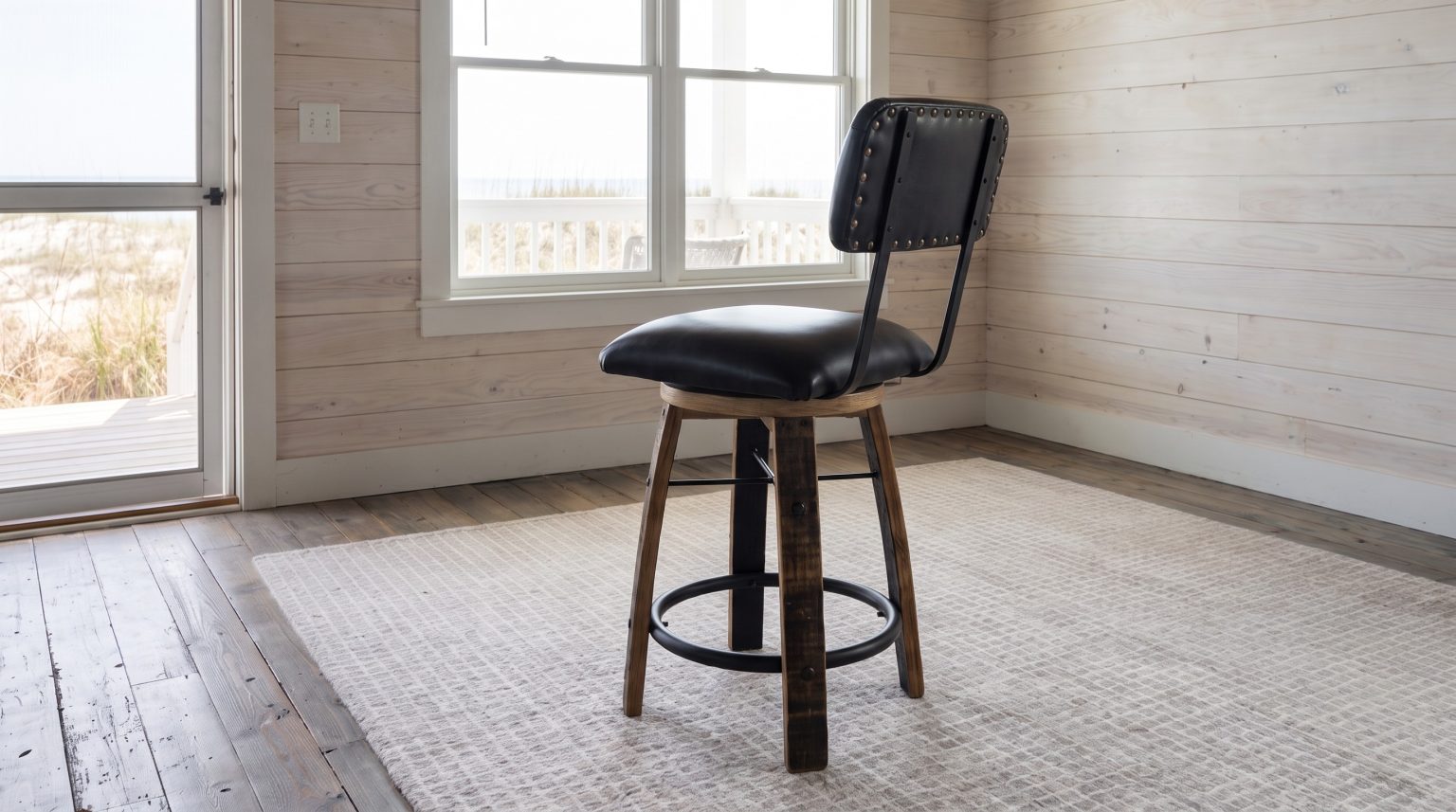 A black leather seat and studded back pad on four barrel-stave legs.