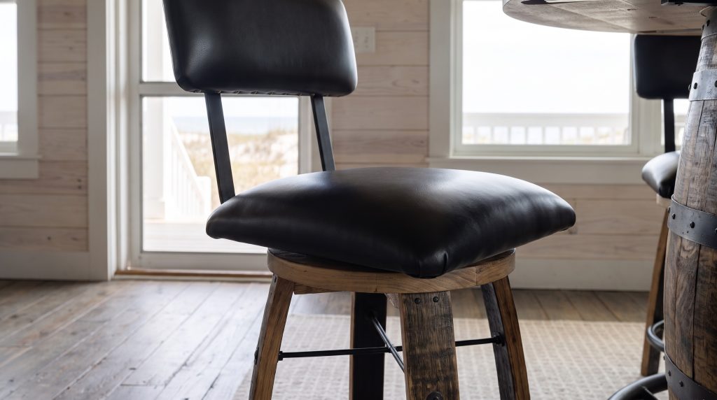 The black leather seat above a weathered barrel-stave leg.