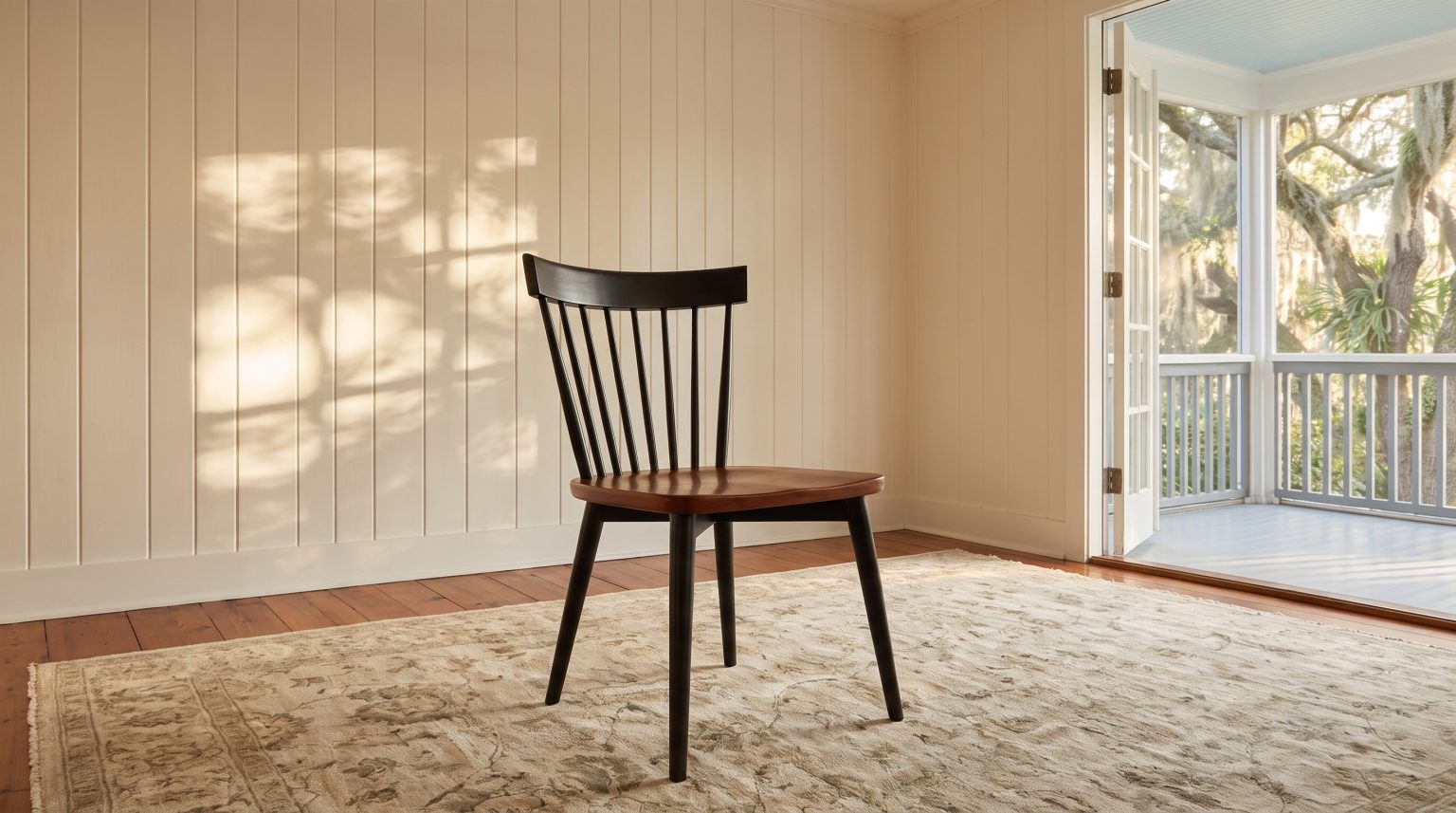 A wide curved crest over slim spindles, a warm wood seat on a black frame.
