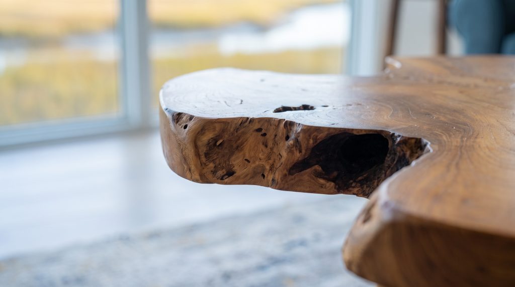 A close view of a raw teak live edge opening into a dark natural void