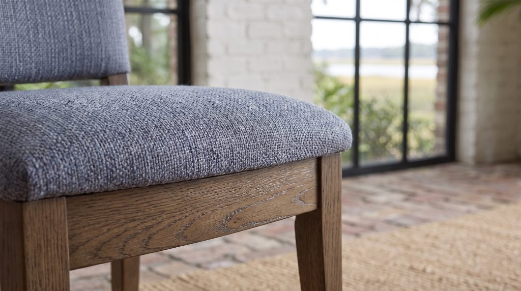 A close view of a blue-gray tweed seat on a gray-brown oak seat rail