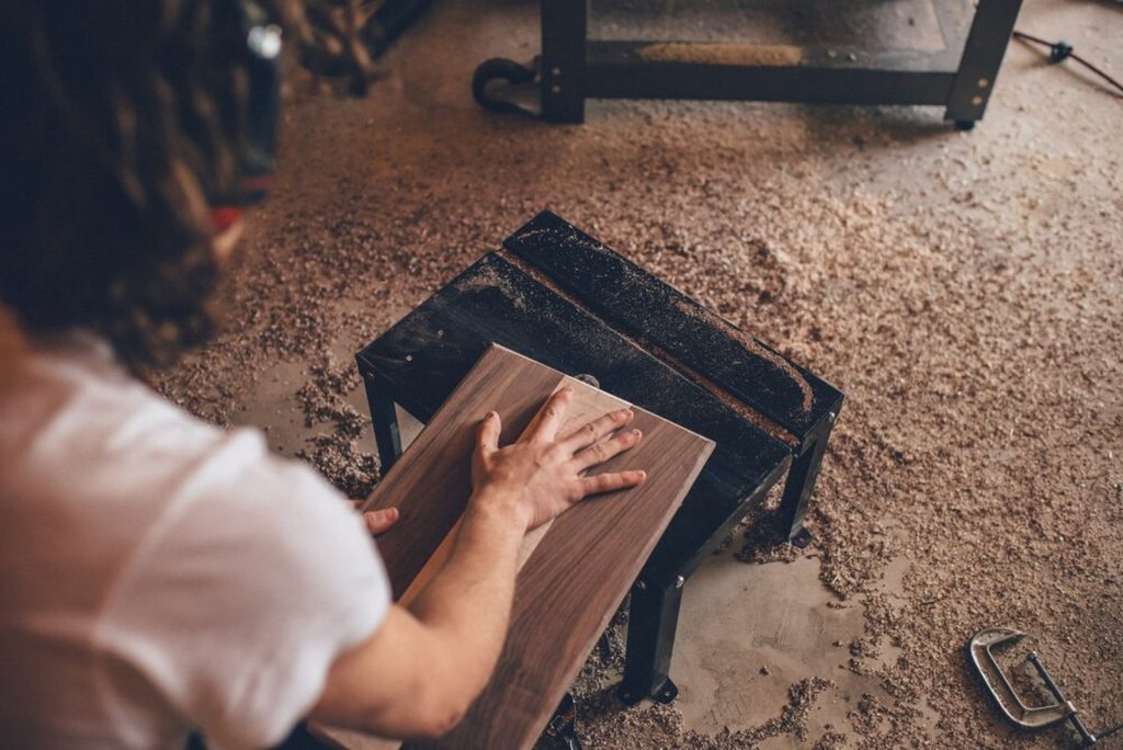 An Amish craftsman sanding solid hardwood by hand