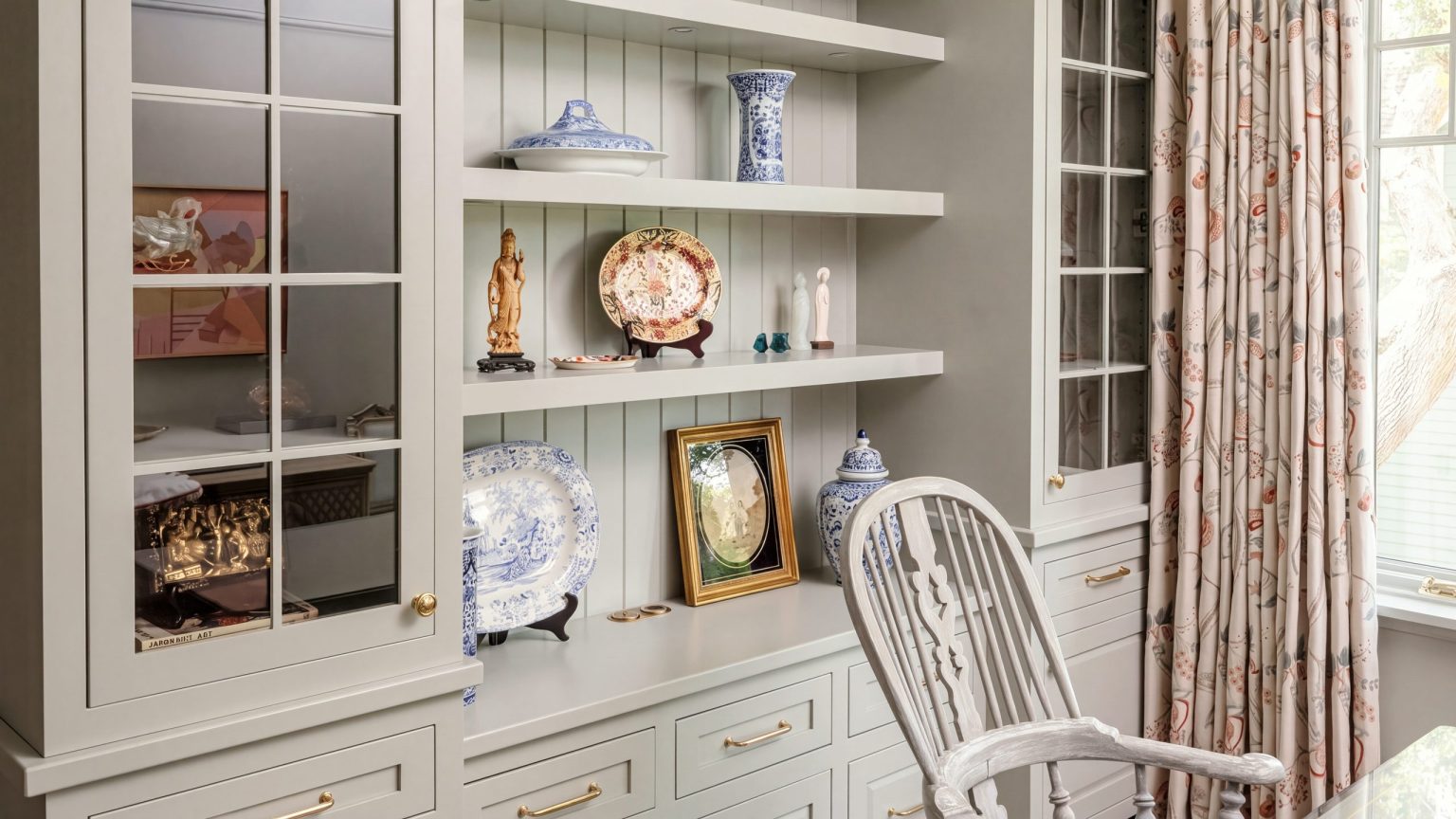 The built-in: Mullioned glass doors either side of beadboard shelving over a drawer base.