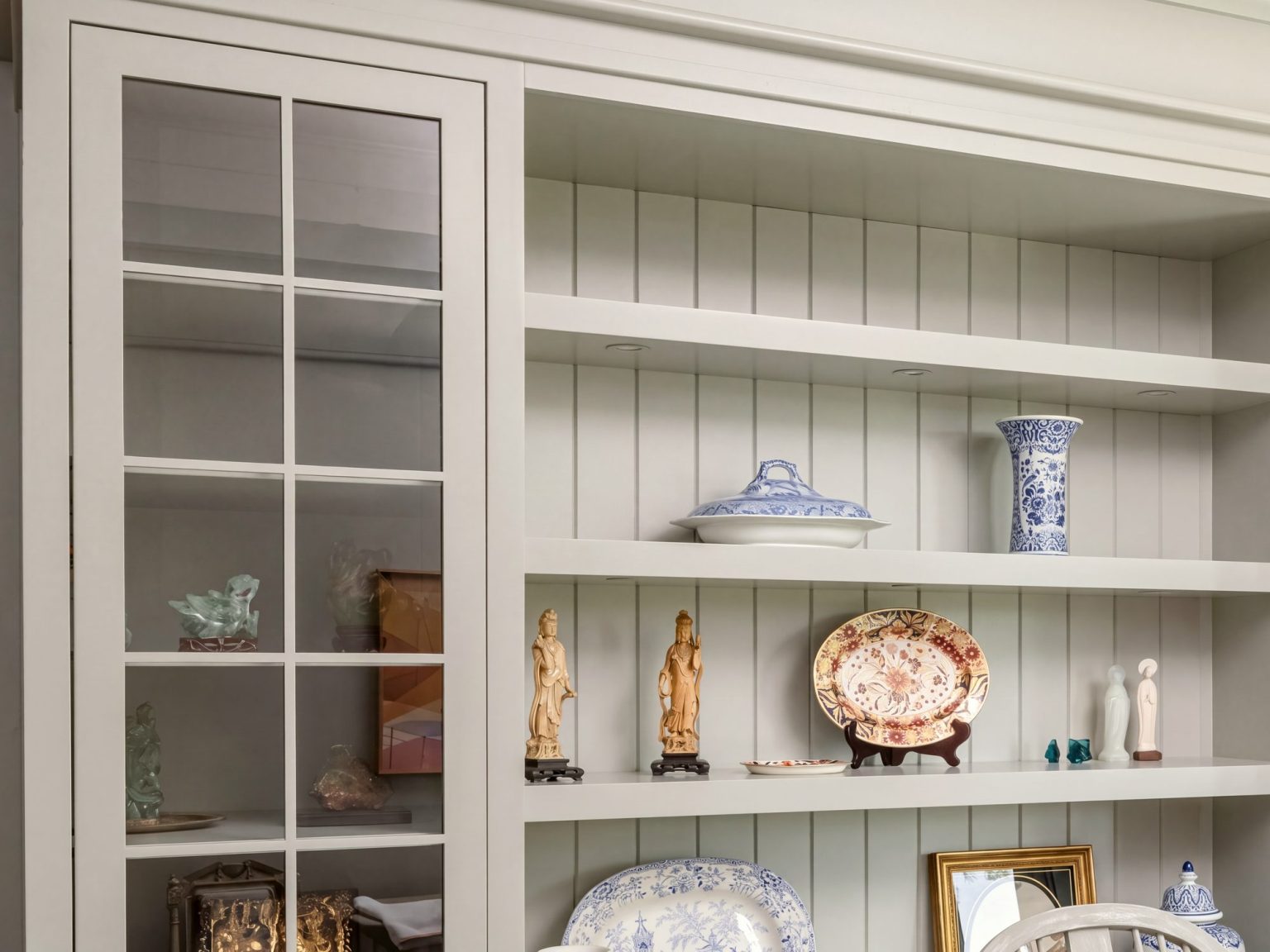 Glass and beadboard: A mullioned glass door beside open shelves with a beadboard back.