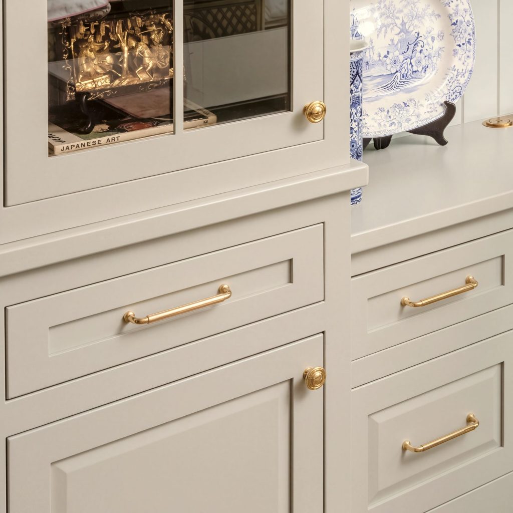 Drawer and door: Inset drawers and a raised-panel door with brass pulls and knobs.