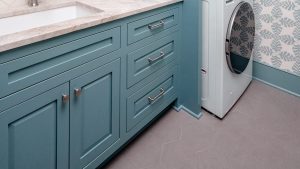 Sink run: Raised-panel doors and a drawer bank under the quartzite top.