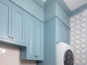 Upper cabinets: Uppers stepping around a tall column beside the stacked machines.