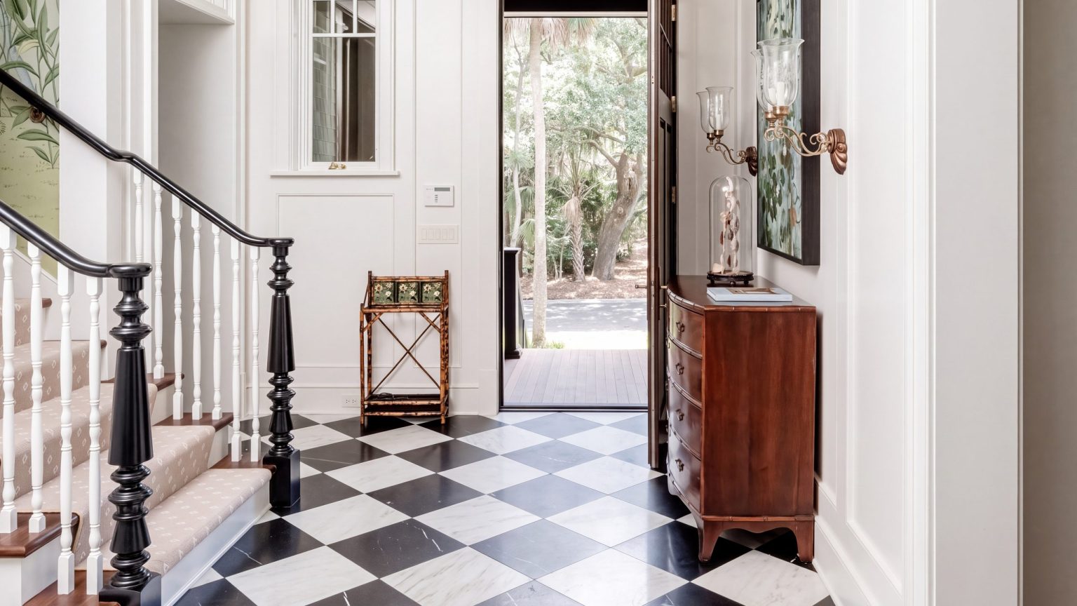 Stair and door: The stair, the paneled hall and the open front door.