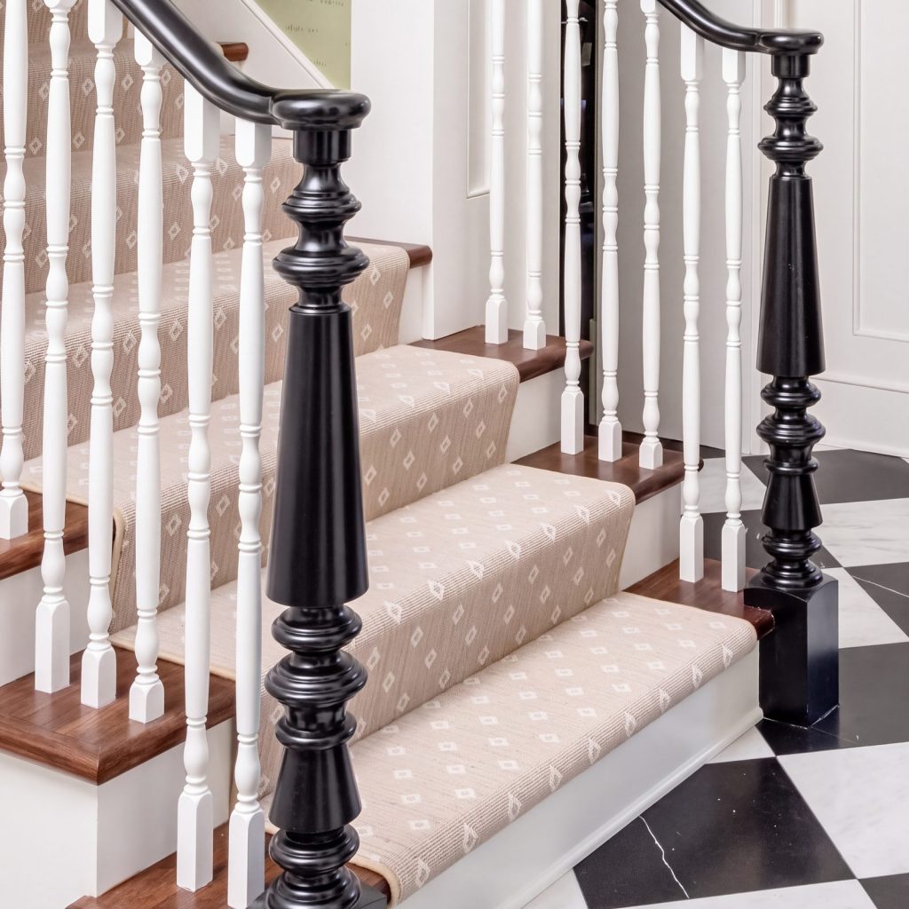 Newel and baluster: A black turned newel beside white turned balusters.