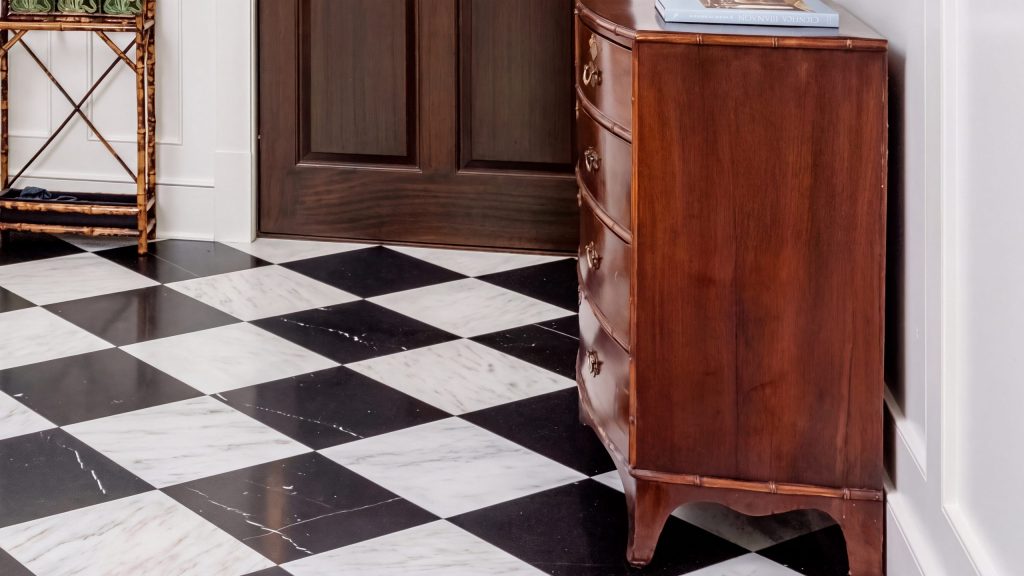 Paneling and marble: Flat-panel millwork, marble floor and a mahogany chest.