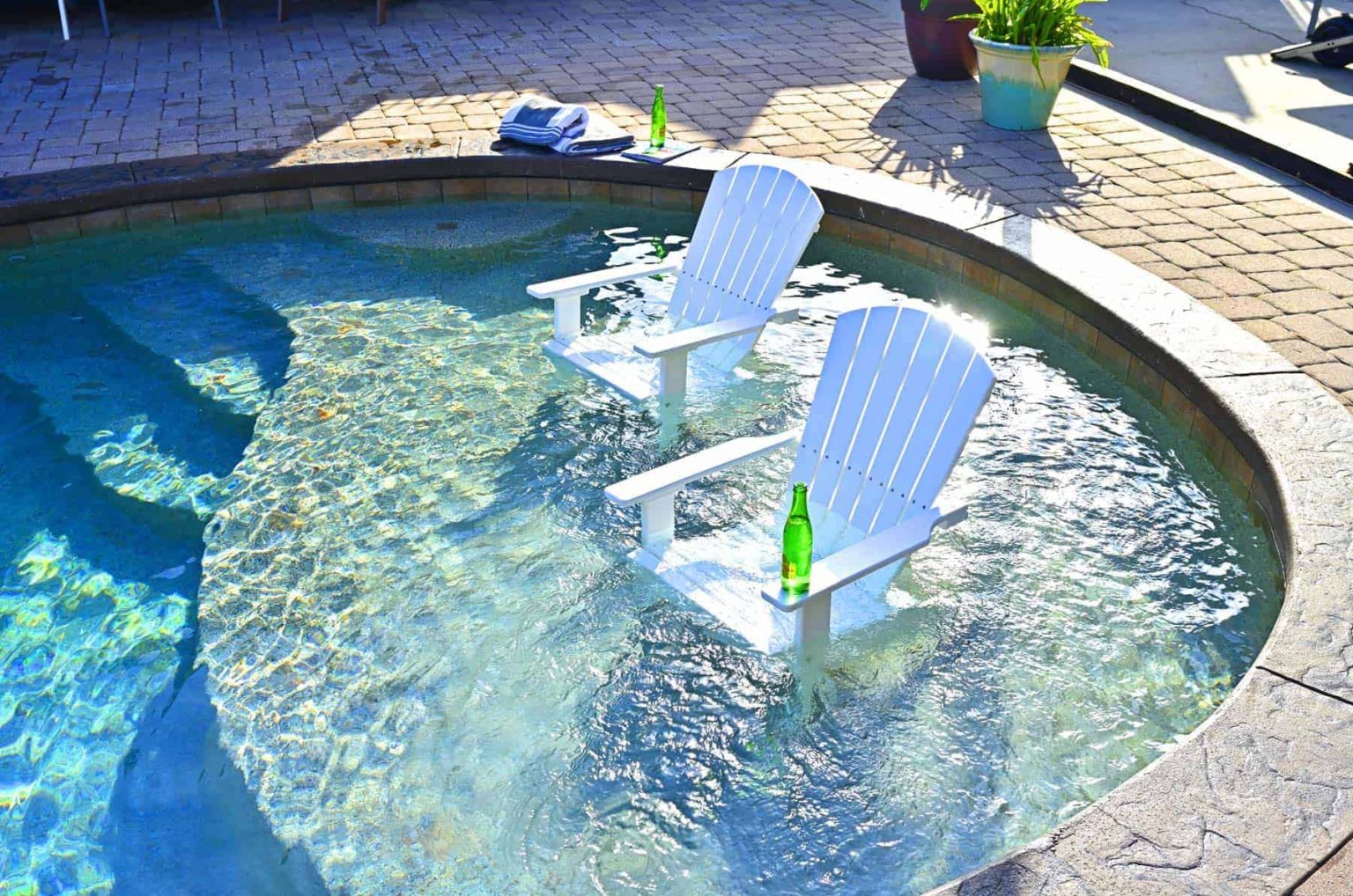 Poly Adirondack chairs standing in the shallow end of a pool