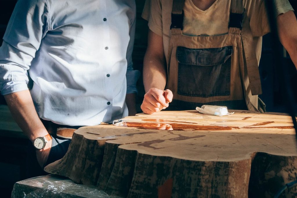 Showroom manager reviewing raw hardwood with an Amish furniture builder