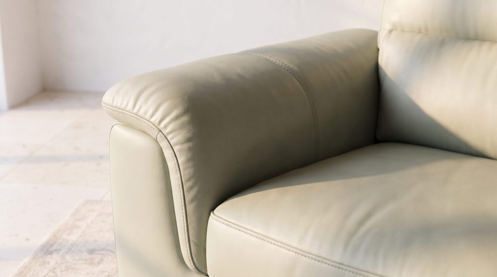 Close-up of sage green leather over the rolled arm and cushion of a chair
