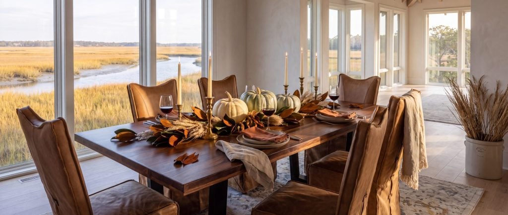 A dining room overlooking the marsh, set for an October evening with heirloom pumpkins, magnolia leaves and candlelight