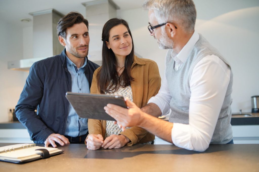 A furniture specialist reviewing options with a young couple